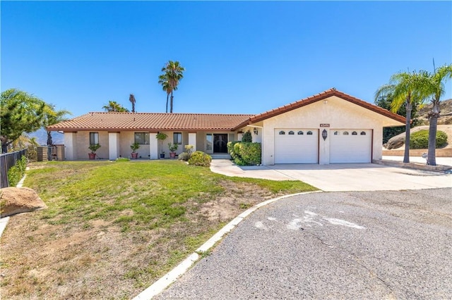 ranch-style house featuring a garage and a front lawn