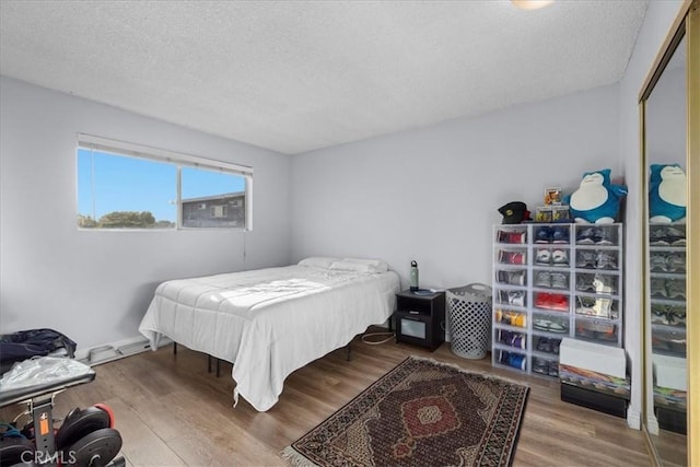 bedroom with a textured ceiling and hardwood / wood-style flooring