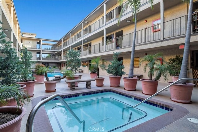 view of swimming pool featuring a hot tub