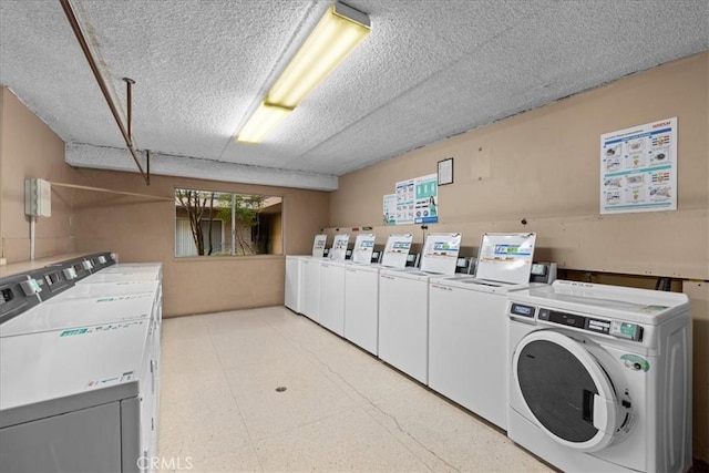 clothes washing area featuring a textured ceiling and washing machine and dryer