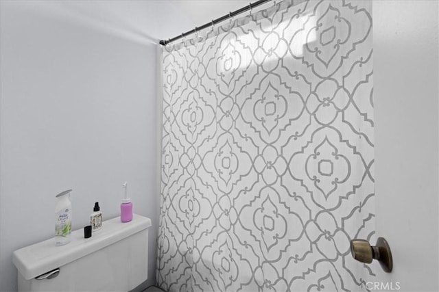 bathroom with curtained shower and toilet