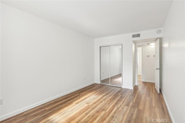 unfurnished bedroom featuring hardwood / wood-style floors and a closet