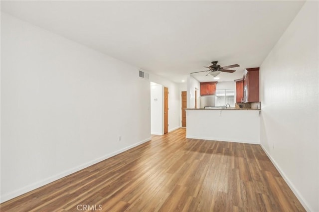 unfurnished living room with ceiling fan and dark hardwood / wood-style floors