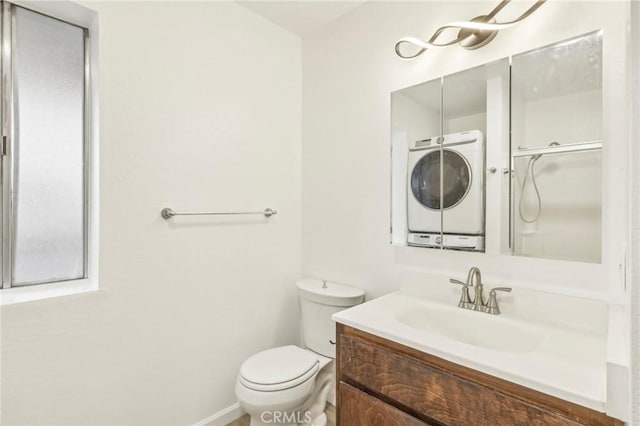 bathroom with toilet, stacked washer / drying machine, and vanity