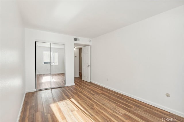 unfurnished bedroom with a closet and wood-type flooring