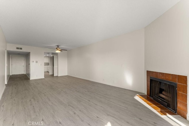 unfurnished living room featuring a fireplace, ceiling fan, and hardwood / wood-style floors