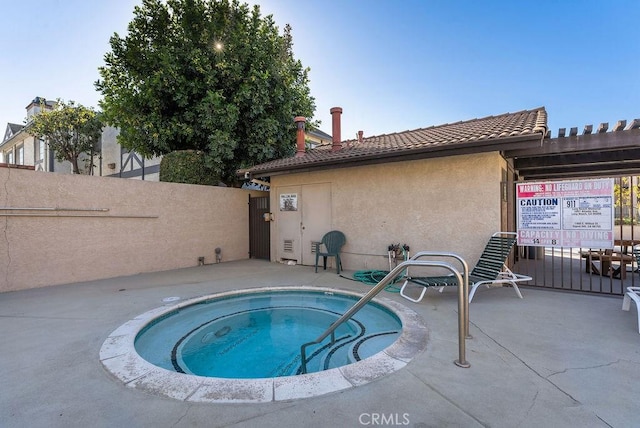 view of swimming pool with a hot tub