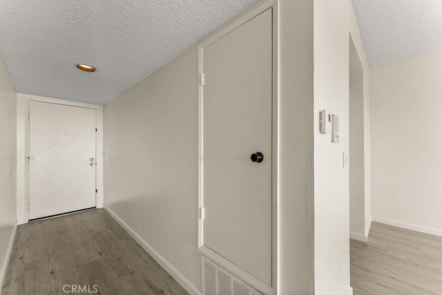 hallway featuring a textured ceiling and light wood-type flooring