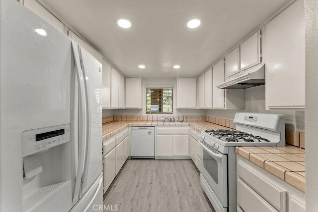 kitchen featuring white cabinets, light hardwood / wood-style floors, white appliances, and tile countertops