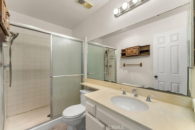 bathroom featuring vanity, toilet, and walk in shower