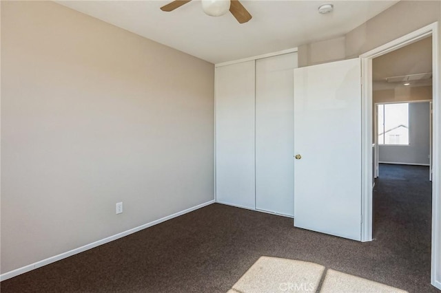 unfurnished bedroom featuring ceiling fan, a closet, and carpet floors