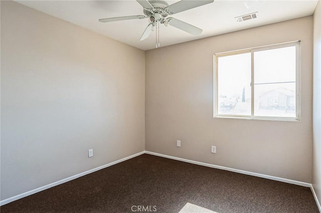 empty room featuring ceiling fan, a healthy amount of sunlight, and dark colored carpet