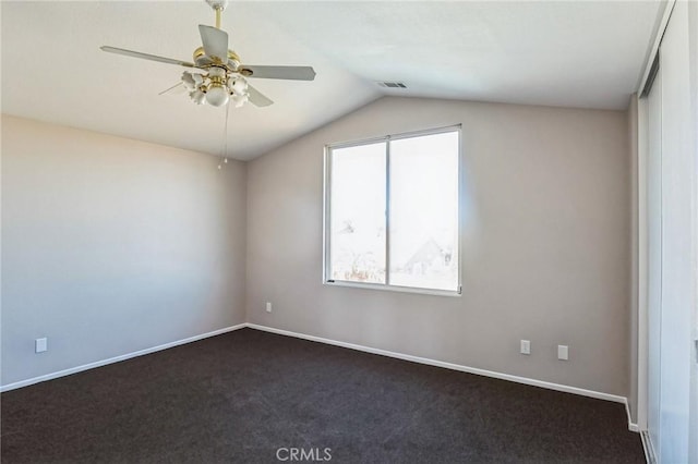 carpeted spare room featuring ceiling fan and lofted ceiling