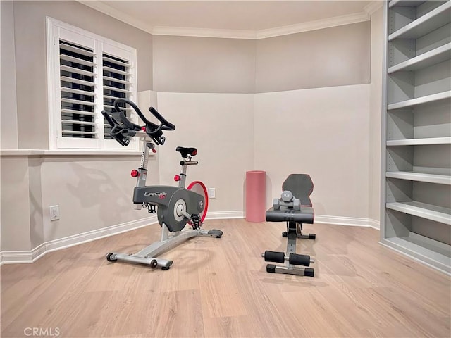 workout area with hardwood / wood-style floors and ornamental molding