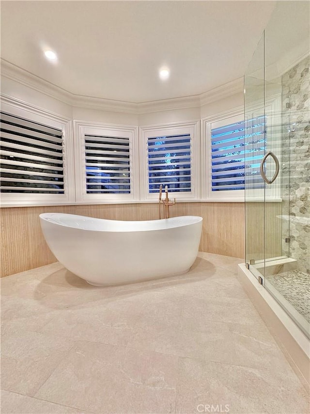 bathroom featuring ornamental molding, shower with separate bathtub, and wood walls