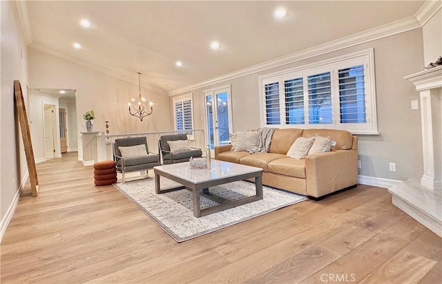 living room with light hardwood / wood-style floors, vaulted ceiling, ornamental molding, and an inviting chandelier