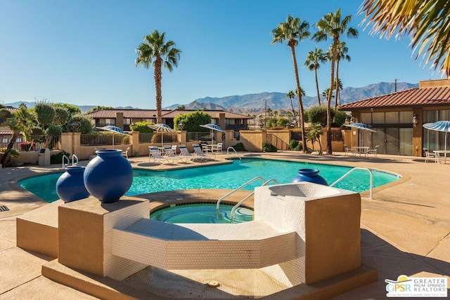 view of pool with a mountain view, a patio, and an in ground hot tub