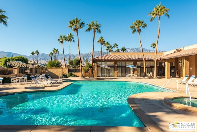 view of swimming pool with a mountain view and a patio area