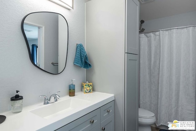 bathroom featuring curtained shower, vanity, and toilet