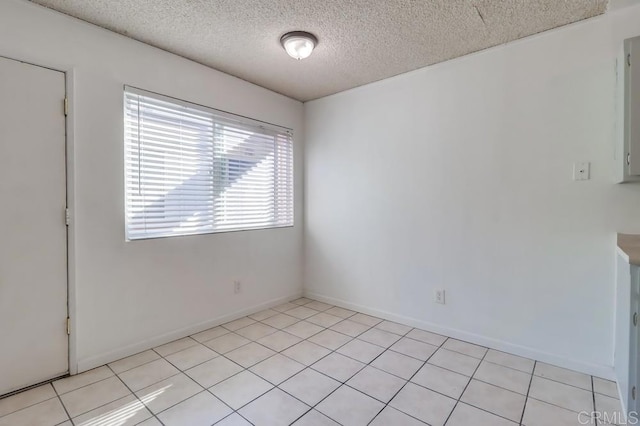 tiled spare room with a textured ceiling