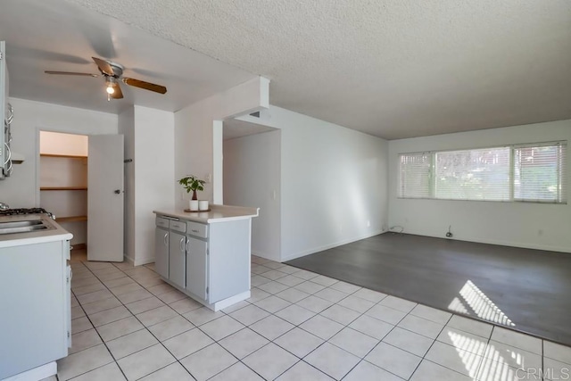 kitchen featuring ceiling fan, light tile patterned floors, and a textured ceiling