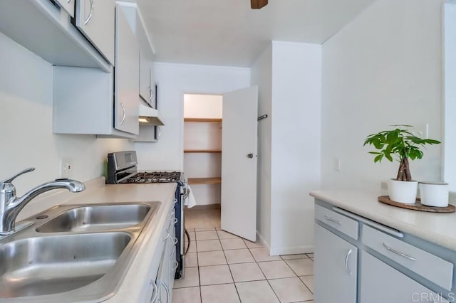 kitchen featuring white cabinetry, light tile patterned flooring, sink, and stainless steel gas stove