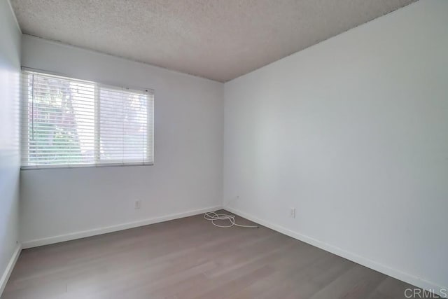 spare room with hardwood / wood-style floors and a textured ceiling