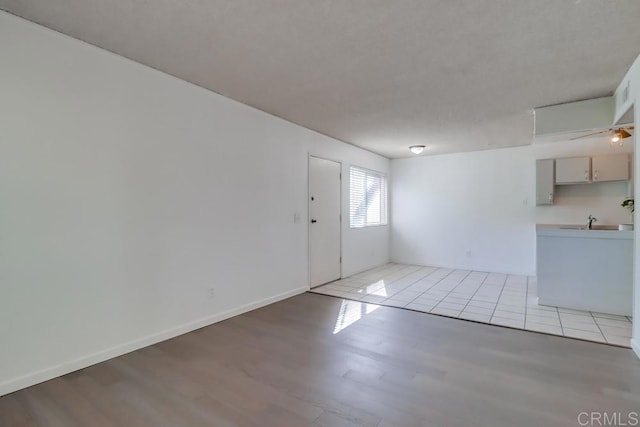 spare room with sink and light hardwood / wood-style flooring