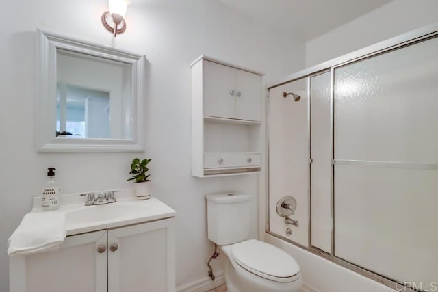 full bathroom featuring vanity, shower / bath combination with glass door, and toilet