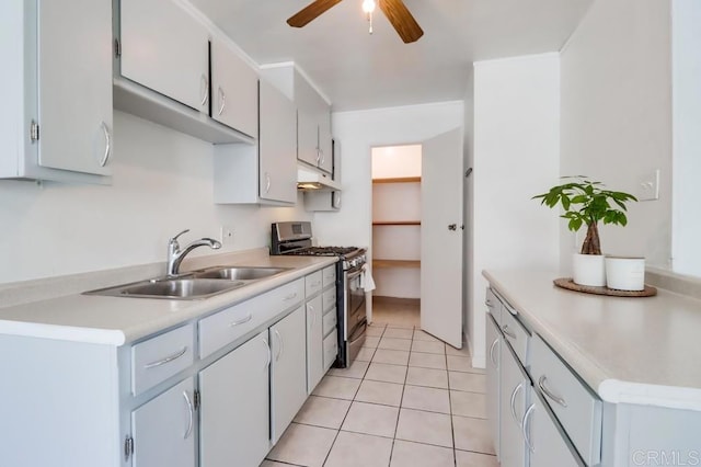 kitchen with sink, stainless steel range with gas stovetop, ceiling fan, and light tile patterned floors