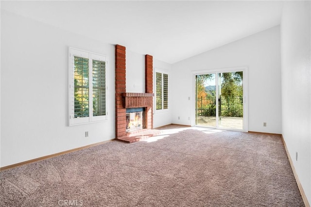 unfurnished living room with carpet flooring, a fireplace, and vaulted ceiling