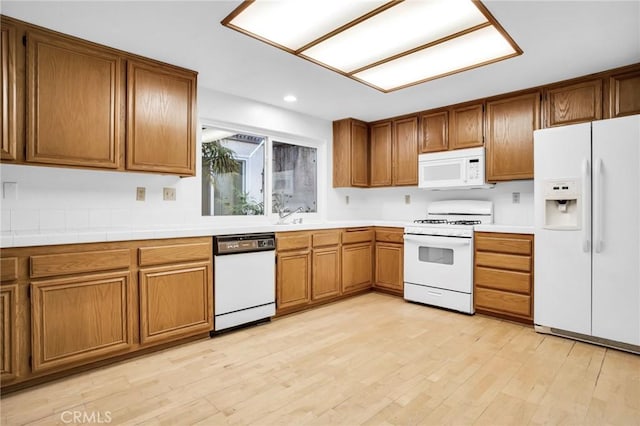 kitchen featuring white appliances and light hardwood / wood-style flooring