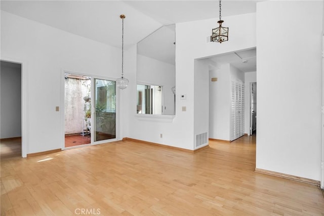 interior space featuring hardwood / wood-style flooring, high vaulted ceiling, and a notable chandelier