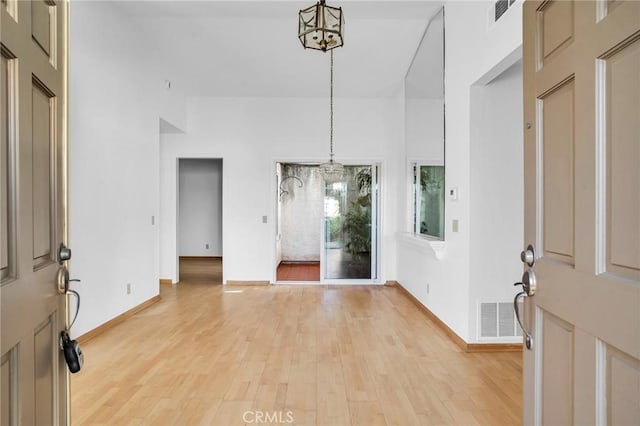 foyer entrance featuring light hardwood / wood-style flooring and an inviting chandelier