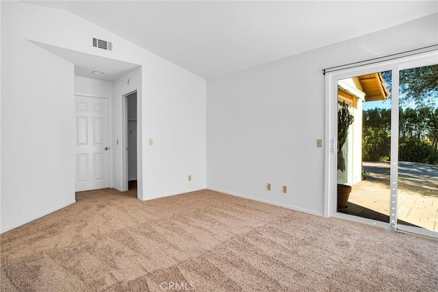 spare room featuring carpet and lofted ceiling