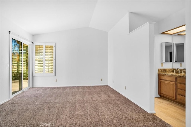 interior space with light colored carpet, vaulted ceiling, and sink