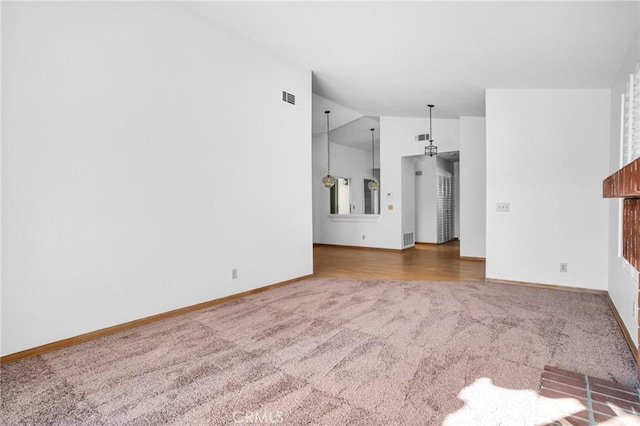 unfurnished living room featuring carpet floors and vaulted ceiling