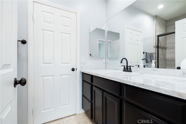 bathroom with tile patterned flooring, vanity, and an enclosed shower