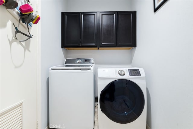 washroom with cabinets and washing machine and dryer