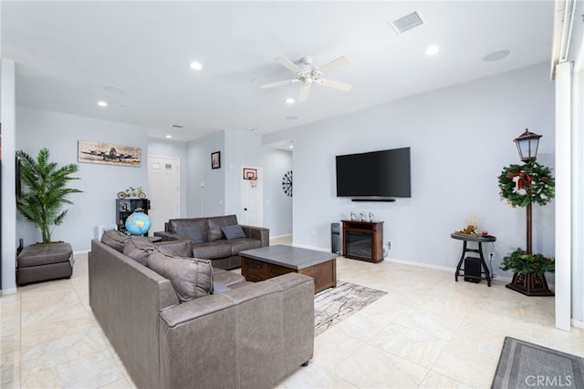 living room with ceiling fan and a fireplace