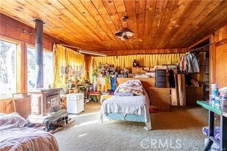 bedroom with carpet floors, wood ceiling, and wood walls