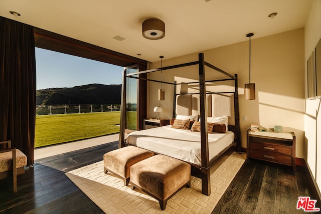 bedroom featuring a mountain view and hardwood / wood-style flooring