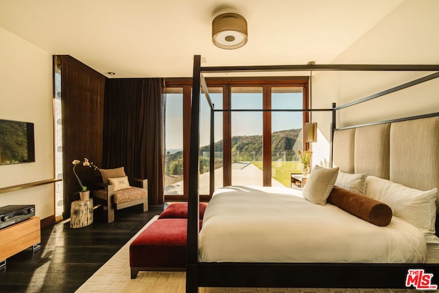 bedroom with a mountain view and hardwood / wood-style floors