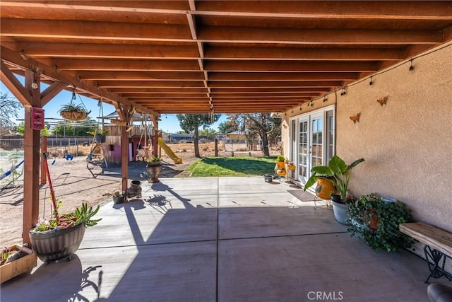 view of patio with french doors and a playground