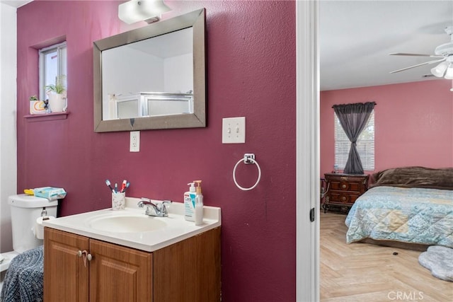 bathroom with toilet, an enclosed shower, parquet floors, vanity, and ceiling fan