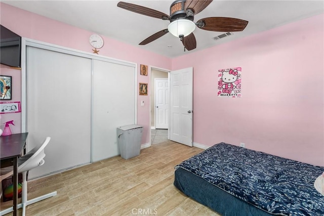 bedroom featuring a closet, ceiling fan, and light wood-type flooring