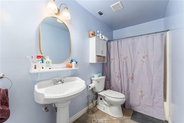 bathroom with toilet and tile patterned flooring