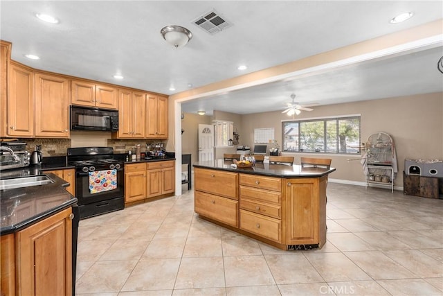 kitchen featuring light tile patterned flooring, a kitchen island, tasteful backsplash, sink, and black appliances