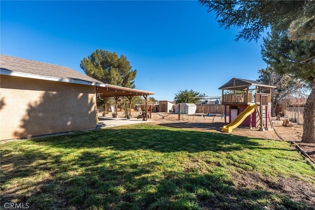 view of yard with a patio area, a playground, and a storage unit