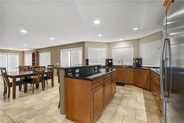 kitchen with a center island, stainless steel refrigerator, and sink